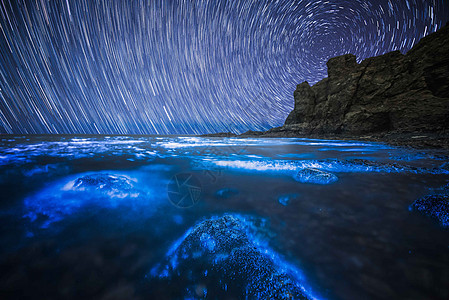荧光海滩下的星轨图片
