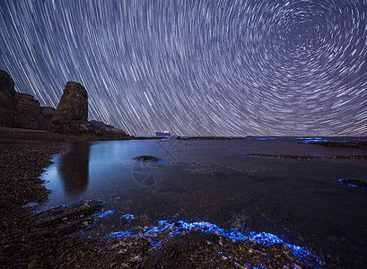 荧光海滩下的星轨背景图片