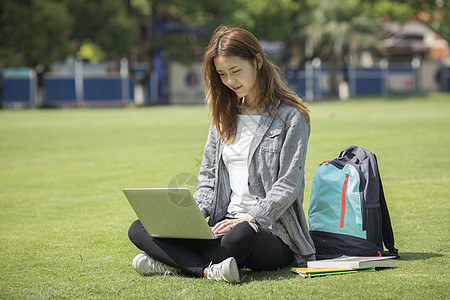 女同学在草坪用电脑学习背景图片