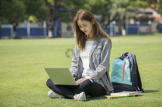 女同学在草坪用电脑学习图片