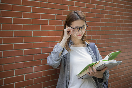 戴眼镜模特女大学生在阅读学习背景