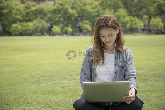 女学生在大学草坪上学习图片