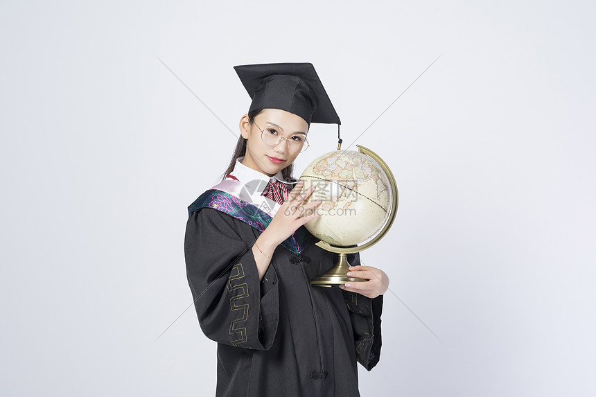 拿着地球仪的毕业女学生图片