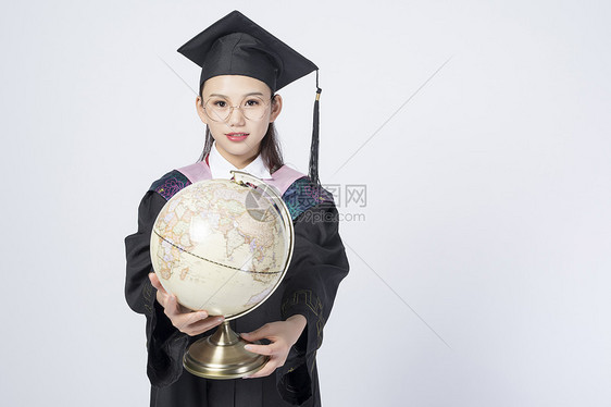 拿着地球仪的毕业女学生图片