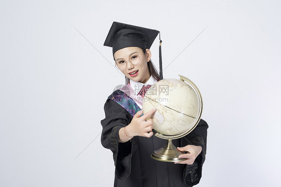 拿着地球仪的毕业女学生图片