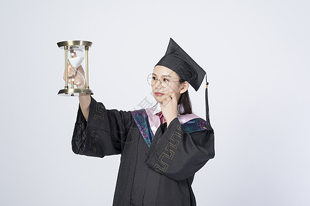 拿着沙漏的毕业女学生图片