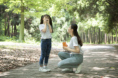 户外妈妈给孩子倒水背景图片