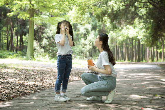 户外妈妈给孩子倒水图片