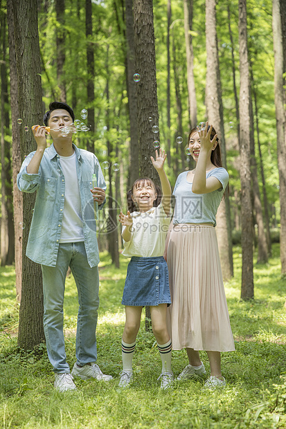 六一儿童节一家人在森林公园吹泡泡图片