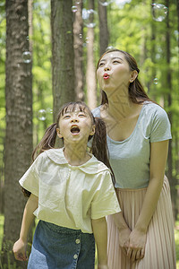 六一儿童节一家人在森林公园吹泡泡背景图片