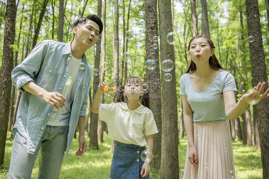 一家人在森林公园吹泡泡图片