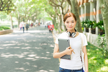 抱书本青春大学生抱着电脑背景