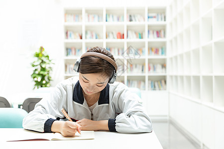 毕业女生高中生书桌听音乐学习背景