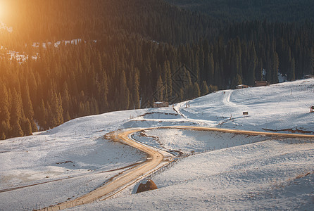 在阳光下雪山里蜿蜒的路图片