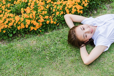 校园写真女生躺在草地上背景