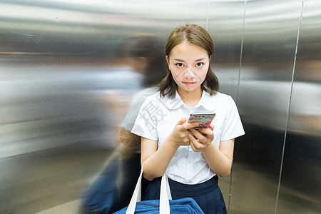 电梯内玩手机的女生图片