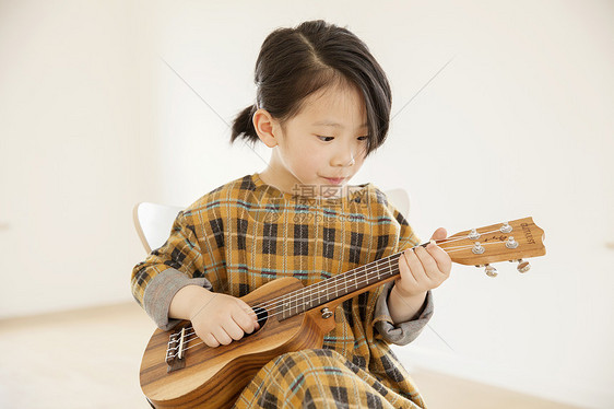 女孩在家里弹尤克里里图片