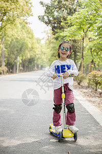 玩滑板车的女孩女孩在玩滑板车背景