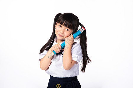 抱着铅笔的穿校服的小女孩高清图片