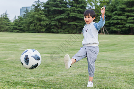 可爱儿童在公园踢足球背景图片