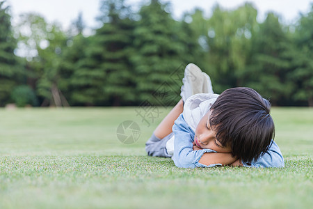 可爱儿童趴在草地上休息图片