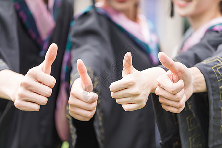 穿学士服的大学生穿学士服的毕业生点赞竖大拇指自拍背景