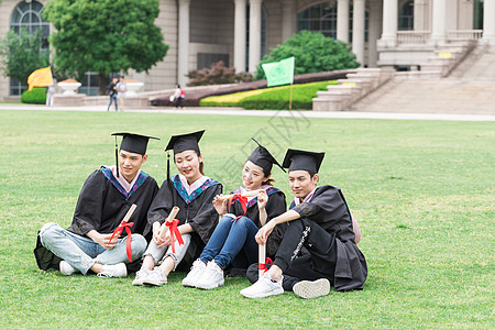 穿学士服坐在开心坐在草地上的大学生图片