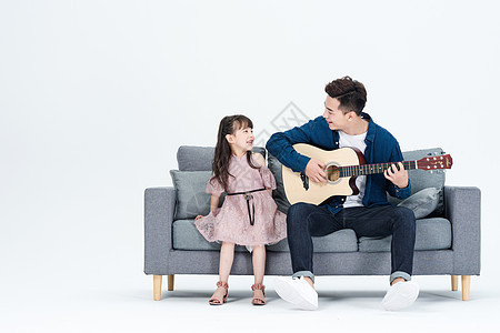 爸爸和女儿在客厅弹吉他背景图片