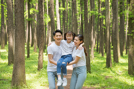 公园森林里父母抱起孩子背景图片