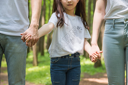 父母牵手孩子一家人公园里牵手特写背景