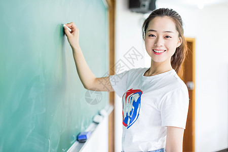 黑板前拿粉笔写字的女生大学高清图片素材