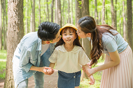 公园森林里父母亲吻孩子背景