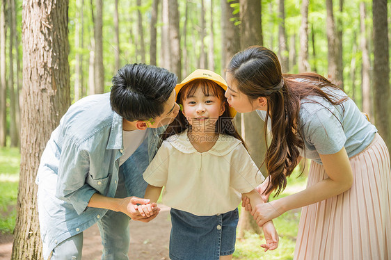 公园森林里父母亲吻孩子