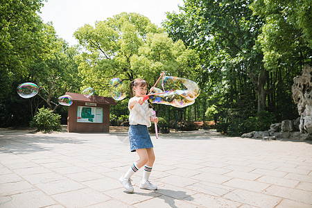 公园里可爱女孩玩吹泡泡图片