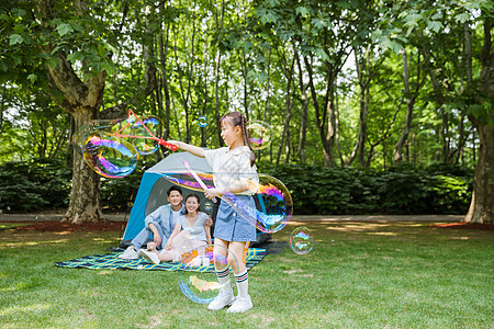 吹泡泡的女孩一家人野营孩子玩吹泡泡背景