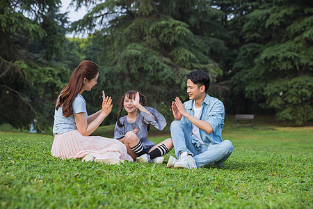 父母教育孩子一家人草地上玩游戏背景