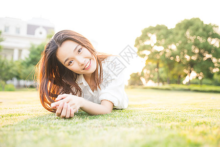 校园女生毕业季青春大学生草地上休息背景