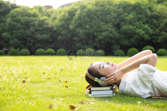 青春学生躺草地上听音乐图片