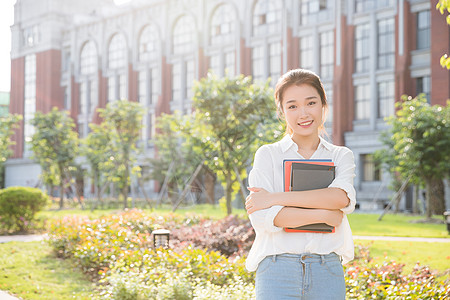 年轻女生大学生抱着书本背景