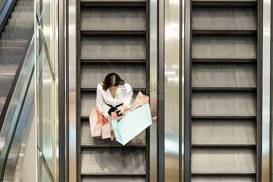 青年女性商场购物坐扶梯图片