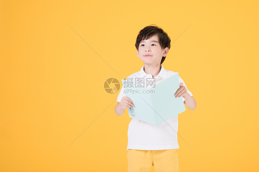 小男孩手持书本学习儿童教育图片