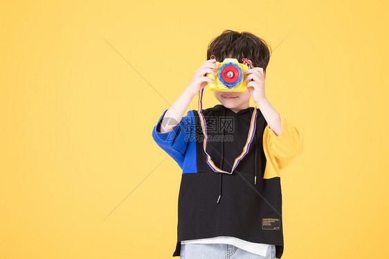 小男孩儿童手拿玩具相机拍照图片