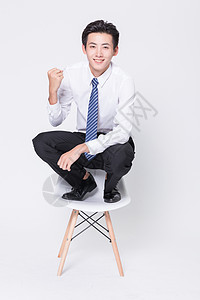 蹲凳子上的商务男性图片
