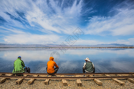 茶卡盐湖旁铁轨上休息的人高清图片
