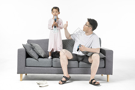 爸爸和女儿在沙发上唱歌高清图片