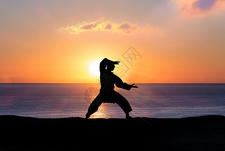 夕阳下功夫人物剪影背景图片