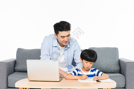 课本与电脑结合沙发上父亲辅导孩子写作业背景
