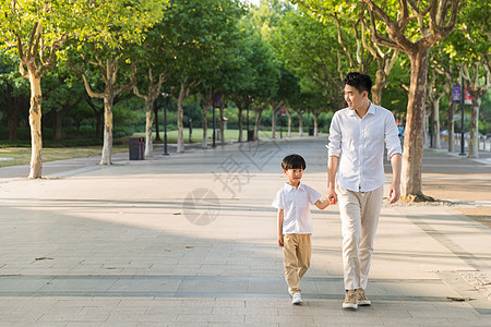 公园里父子牵手散步图片