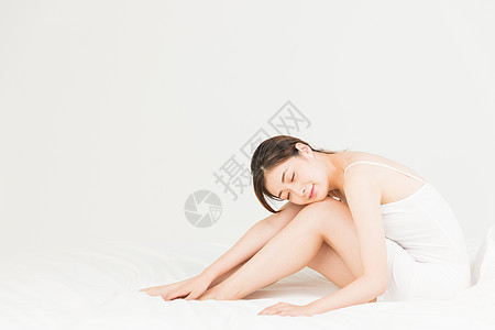 年轻女性坐床上休息图片