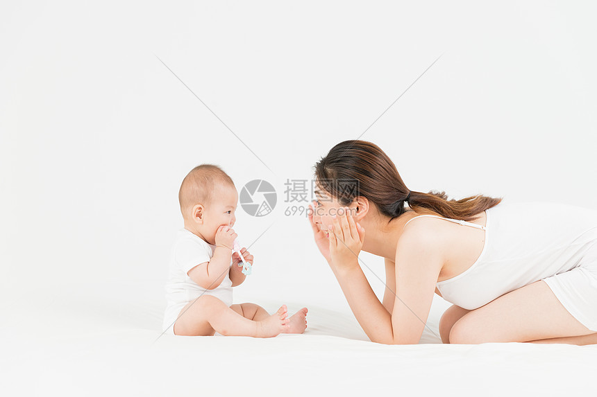 母婴妈妈在床上逗宝宝开心图片
